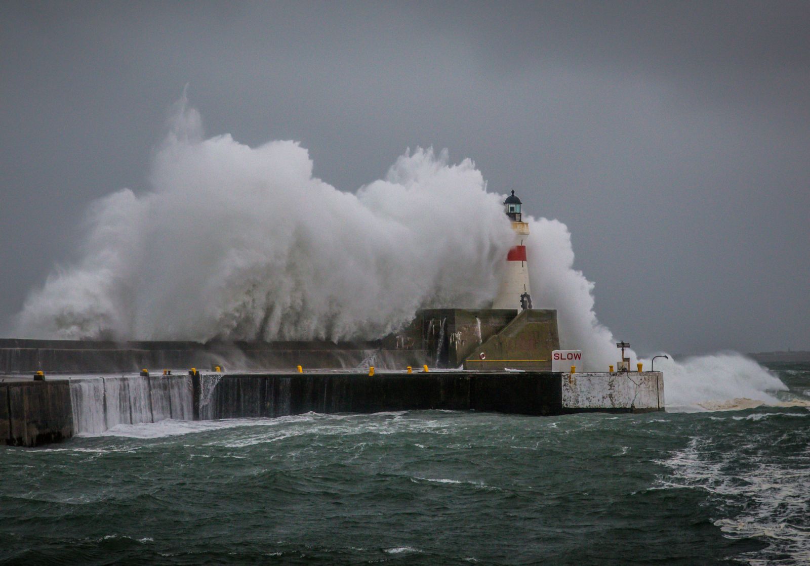 Stormy waves crashing over the harbour wall at Fraserburgh banner image