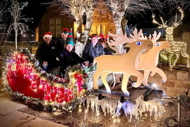 Santa's sleigh with coloured lights and happy crowd