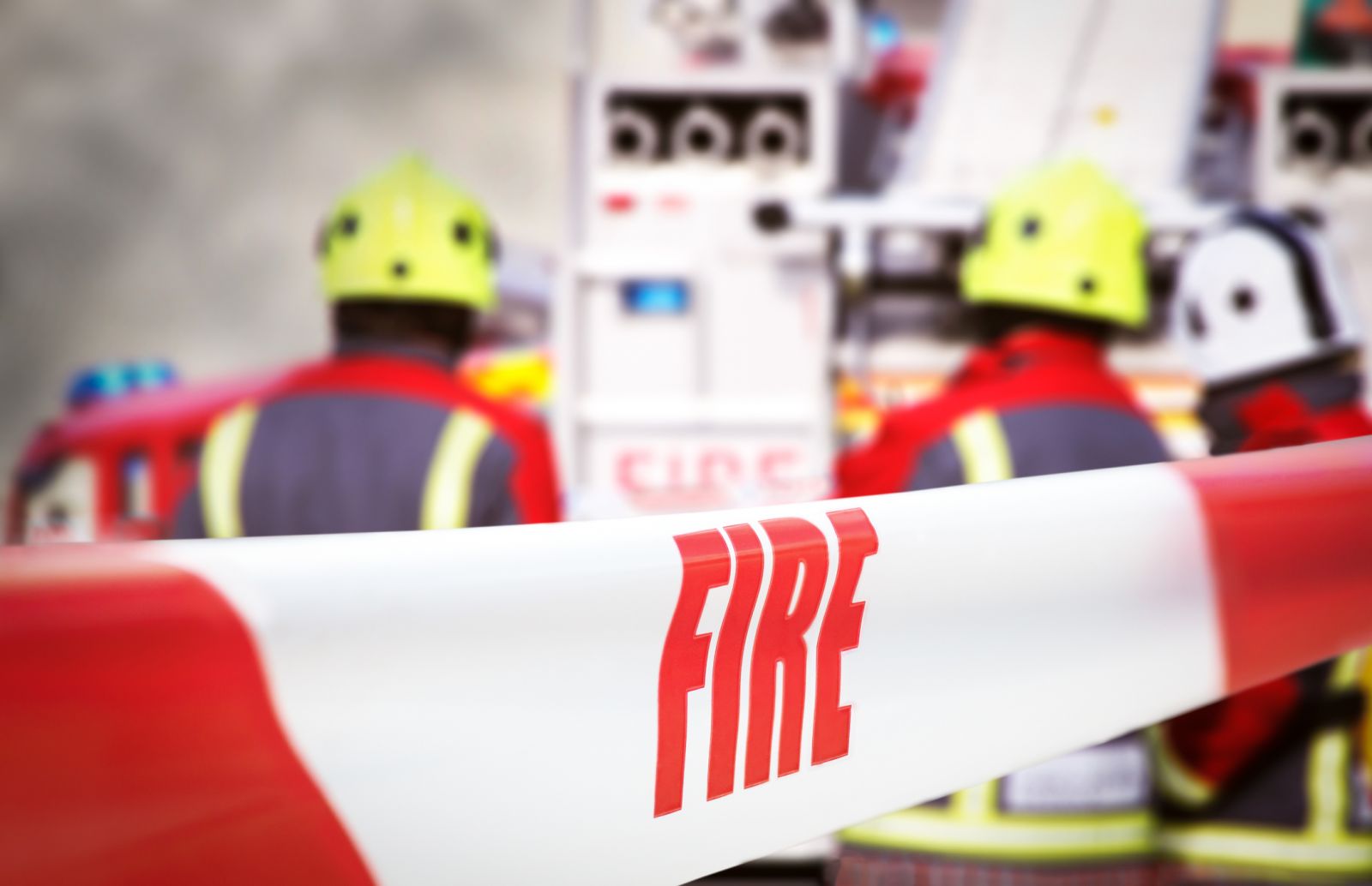Incident sealed off by fire tape with a fire engine in the background banner image