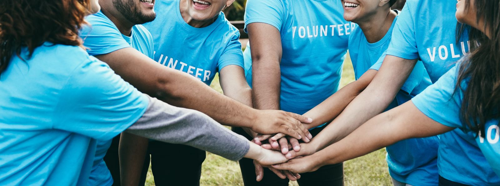 Group of people in blue volunteers t-shirts in a group banner image